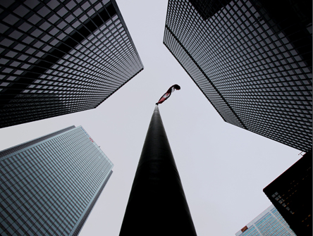 Bottom view of Canada flag on flag pole surrounded by buildings