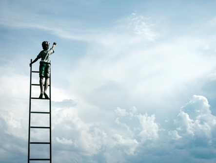 Boy on ladder reaching for the sky