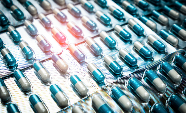 Blue and white capsules pill in blister pack arranged in a pattern