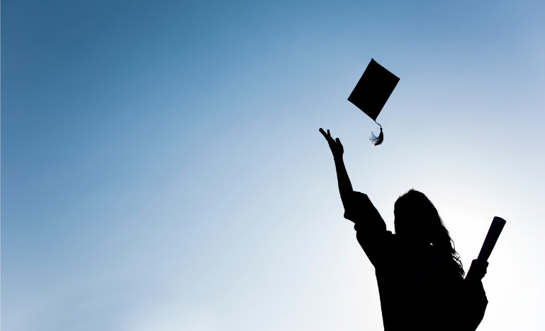 Law grad tossing up hat over blue sky