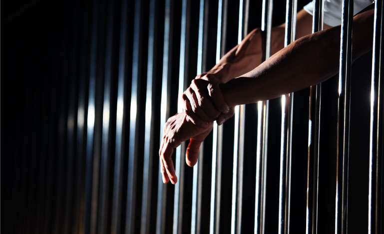 Close up of hand in jail background