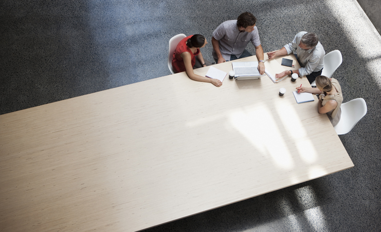 People negotiating at corner of table