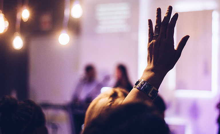 Woman in crowd with hand in the air