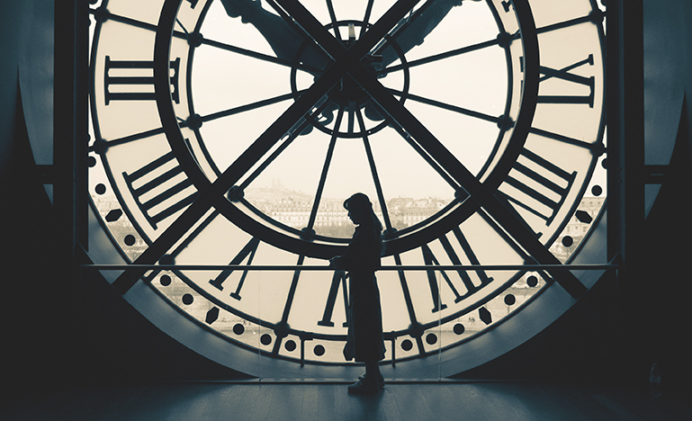 Image of a woman in the shadows of a huge clock