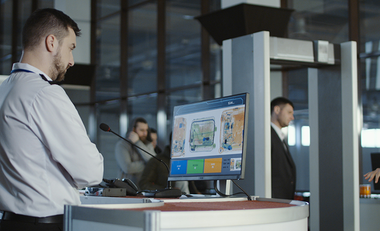 Airport worker exploring x-ray of baggage
