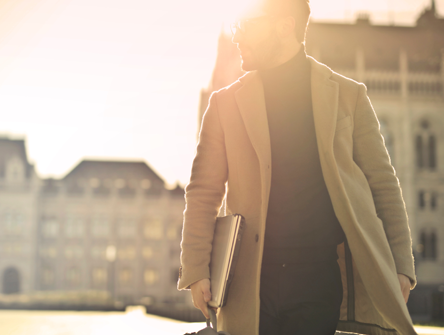 Man walking with computer and backpack.
